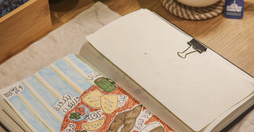 Top view of a sketchbook, plants, and tea on a wooden desk.